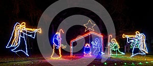 nighttime manger scene with baby Jesus, Mary, three wisemen and angel with trumpet