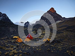 Nighttime scene featuring several camping tents in front of mountain landscape in Condoriri Bolivia