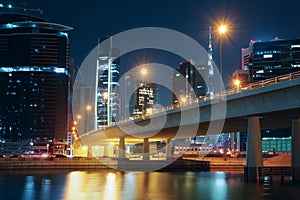 Nighttime skyline of Dubai with modern buildings, street lights and a bridge