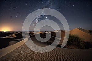 nighttime stars over the dunes of a desert, with crescent moon in view