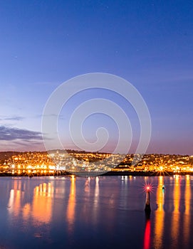 Nighttime view of the seaside port of Teignmouth from across the river Teign in Shaldon