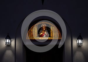 Stained glass window featuring Jesus Christ above the entrance to Saint Mary`s Catholic Church in Marfa, Texas.