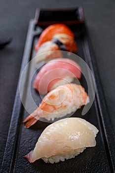 Nigiri sushi set on black plate, close up