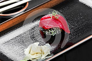 Nigiri with tuna on dark wooden background. Gunkan Sushi set. Japanese cuisine.