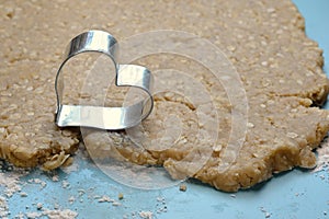 Heart-shaped cookie cutter on raw organic dough