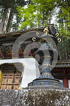 NIKKO, JAPAN - MAY 11: A shinto priest sweeps under the Yomeimon gate May 11, 2014 in Nikko, JP. Founded in 1617, the remains