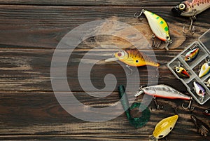 Nikolaev, Ukraine - 08 july, 2022: Colorful fishing lures, wobbler, spinner, on brown wood desk different fishing baits