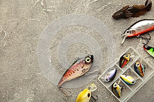 Nikolaev, Ukraine - 08 july, 2022: Colorful fishing lures, wobbler, spinner, on grey wood desk different fishing baits