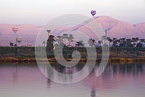 Nile river at sunrise with hot air balloons in Luxor, Egypt.