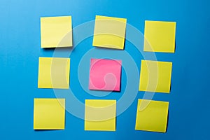Nine Blank Sticky Notes on Blue Wall with Pink Note Center