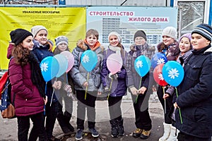 Nine children stand together holding balloons in photo