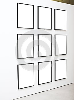 Nine empty frames on white wall exhibition