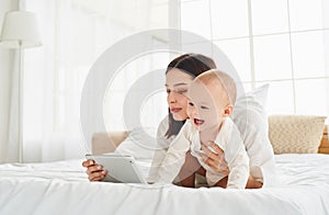 Nine-month-old baby with mom looking at the screen of a digital tablet