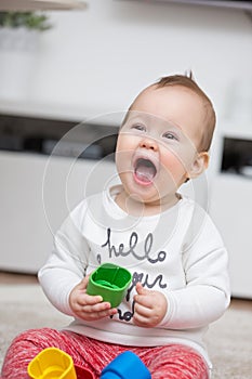 Nine months old baby girl playing with her toys