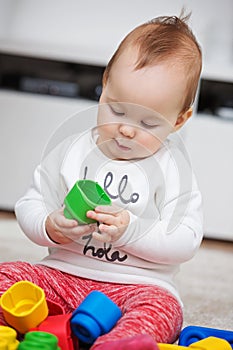 Nine months old baby girl playing with her toys