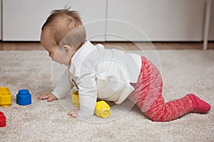 Nine months old baby girl playing with her toys