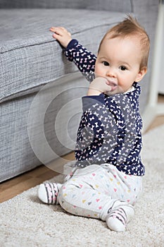 Nine months old baby girl sitting on the floor