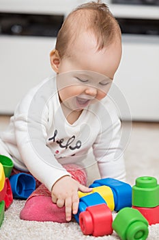 Nine months old baby girl sitting on the floor