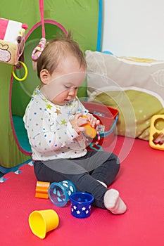 Nine months old baby girl sitting on the floor