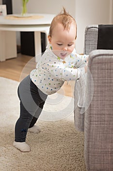 Nine months old baby girl standing on her feet