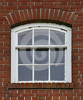 Nine pain glass window set in a red brick wall