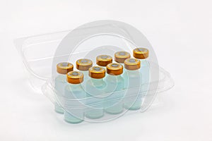 Nine vaccine bottles inside opened translucent plastic box