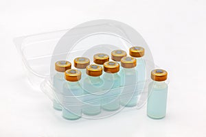 Nine vaccine bottles inside opened translucent plastic box and one outside