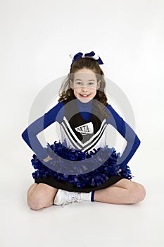 Nine year old Caucasian girl dressed in a blue cheerleader outfit