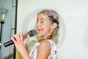 Nine year old girl singing with microphone