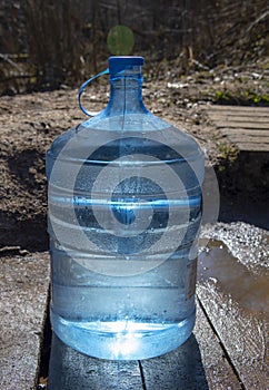 A nineteen-liter water bottle on a wooden walkway