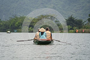 Tourist boat trip on Ngo Dong river in Trang An Hang Mua, Vietnam. Beautiful nature of North Vietnam near Hanoi photo