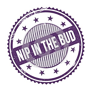 NIP IN THE BUD text written on purple indigo grungy round stamp