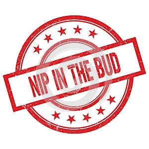 NIP IN THE BUD text written on red vintage round stamp