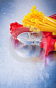 Nippers tying cables on scratched metallic background