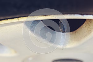 Nipple cap on the wheel. Place the air replenishment tires. Toned background with selective focus and copy space