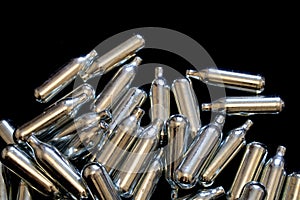 Nitrous Oxide Metal Bulb Canisters Recreational Drugs on Black Background