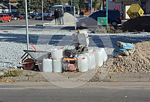 NIZHYN, UKRAINE - November, 15, 2023: Portable Generator, wheel barrow, gravel, sand, cement mixer on the road construction site