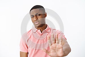 No bro thanks. Serious-looking displeased strict african american masculine guy pulling hand forward in stop and