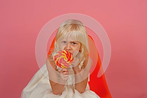 No child can resist these exciting yummy treats. Small girl hold lollipop on stick. Small child with sweet lollipop