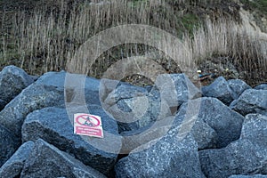 No Climbing sign attached to recently deployed sea defence rocks.