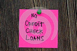 No Credit Check Loans write on sticky notes isolated on Wooden Table. Business or Financial Concept