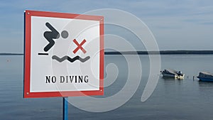 No Diving sign at beach, lake Naroch, Belarus. Warning sign of shallow water. Warning notice sign do not jump in water.