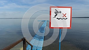 No Diving sign at beach, lake Naroch, Belarus. Warning sign of shallow water. Warning notice sign do not jump in water