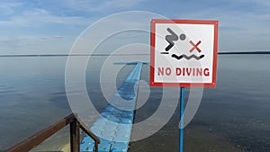 No Diving sign at beach, lake Naroch, Belarus. Warning sign of shallow water. Warning notice sign do not jump in water