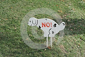 No dog toilet sign on a lawn. symbol of dog pooping prohibition
