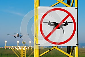 No drone zone sign on approach lighting system at runway. Airport airspace perimeter prohibition drones