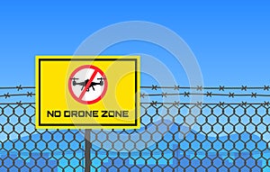 No drone zone sign hanging on barbed wire border restricted area