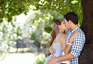 No else in the world right now.... A young couple kissing in the park.