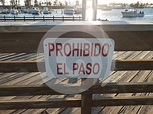 No entrance prohibido el paso sign on wood fence with water and boats photo