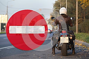 No entry sign and motorcyclist standing by the roadside, collage